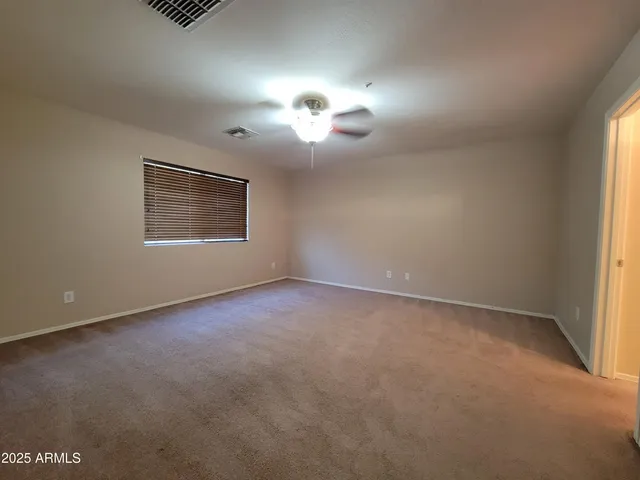 a view of a room with a chandelier fan and windows