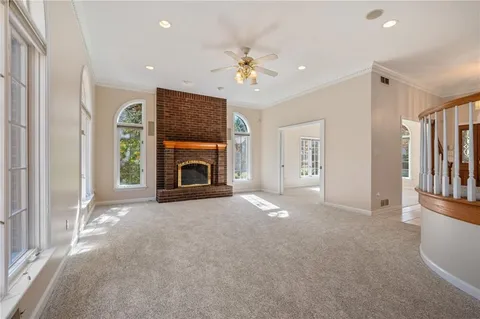 a view of empty room with fireplace and fan