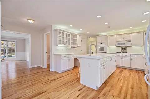 a large kitchen with stainless steel appliances granite countertop a large stove a sink dishwasher and a refrigerator with wooden floor