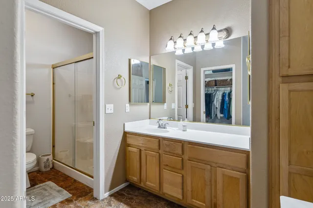 a spacious bathroom with a granite countertop sink a mirror and a shower