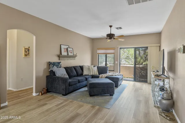 a living room with furniture large window and a flat screen tv