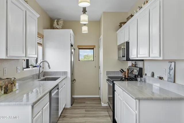 a kitchen with stainless steel appliances granite countertop a sink stove and cabinets