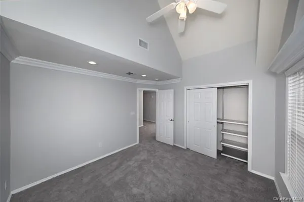 a view of an empty room with a chandelier fan