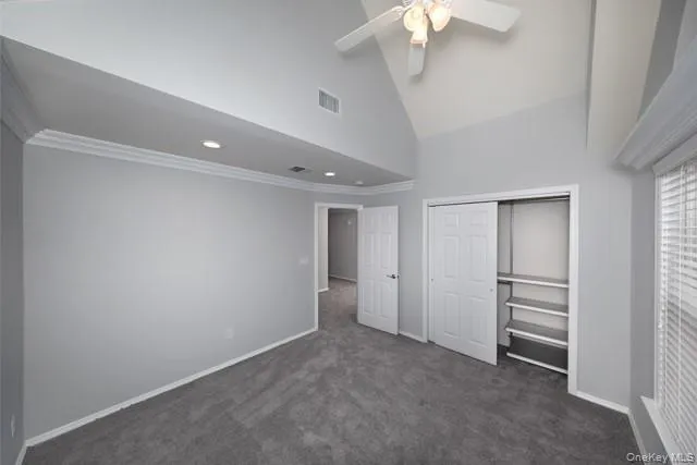 a view of an empty room with a chandelier fan