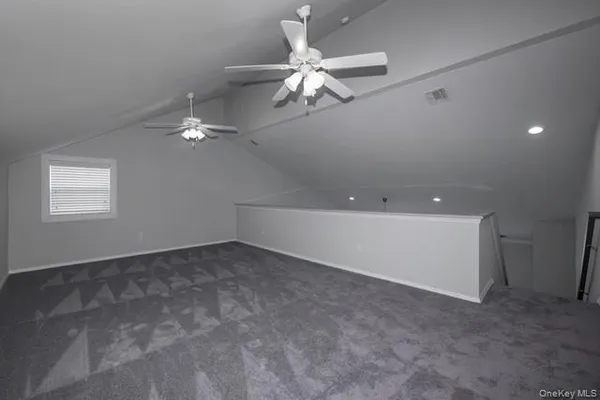 a view of an empty room with a ceiling fan