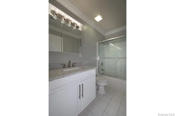 a bathroom with a granite countertop sink a toilet and a mirror