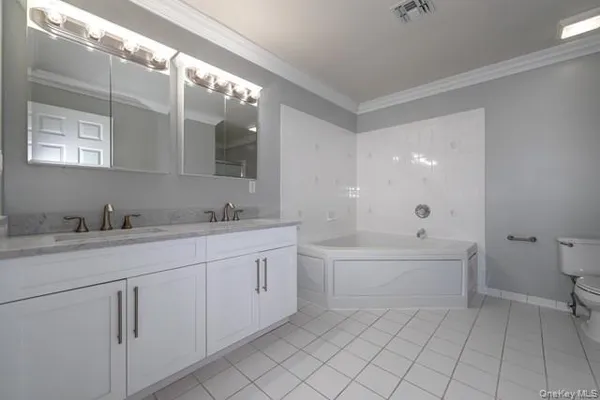 a spacious bathroom with a granite countertop sink mirror and a bathtub