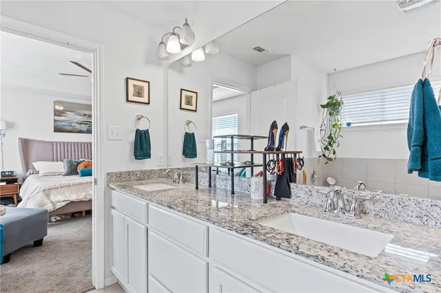 a bathroom with a granite countertop sink a large mirror and a window