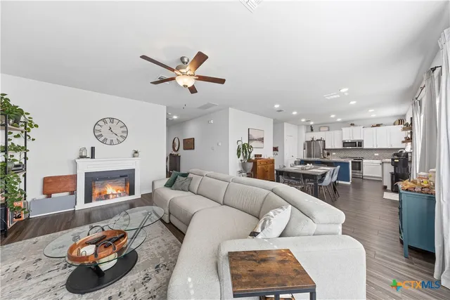 a living room with furniture kitchen view and a fireplace