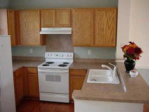 120 South Square Row Davidson, NC 28036 - Photo 3 of 8 a kitchen with granite countertop wood cabinets and white appliances