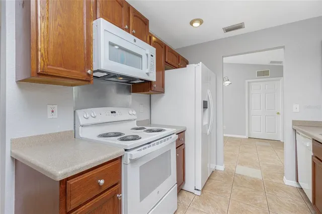 a kitchen with stainless steel appliances granite countertop a stove a refrigerator and a cabinets