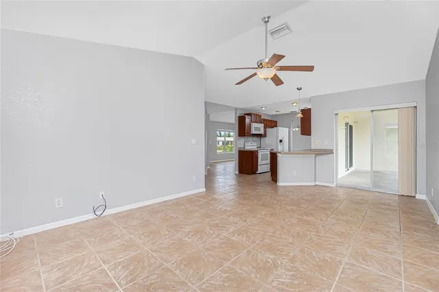 a view of a kitchen with a stove cabinets a ceiling fan and wooden floor