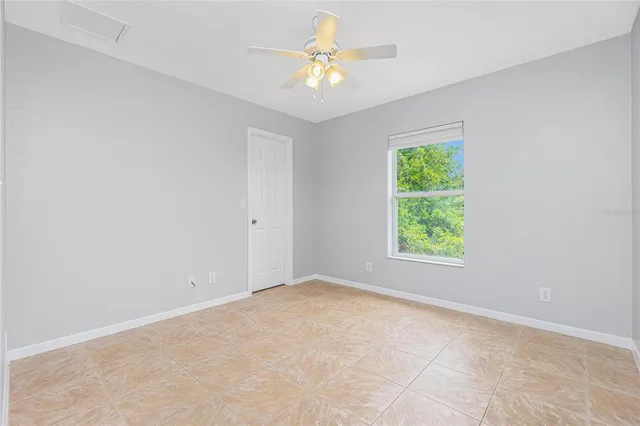 an empty room with a window and a fan
