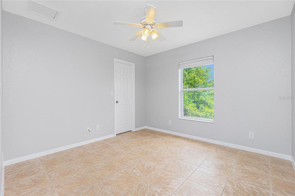11708 Willmington Boulevard Port Charlotte, FL 33981 - Photo 23 of 41 an empty room with a window and a fan