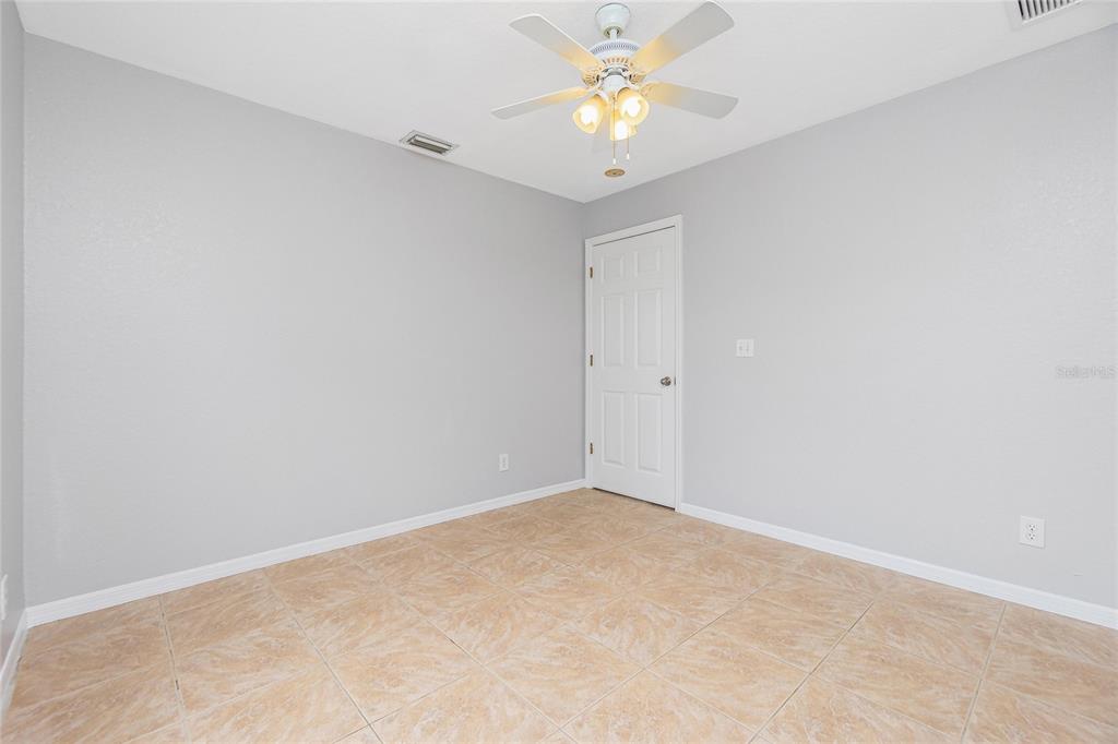 11708 Willmington Boulevard Port Charlotte, FL 33981 - Photo 24 of 41 an empty room with a window and a chandelier fan