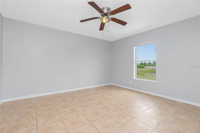 an empty room with a window and a fan