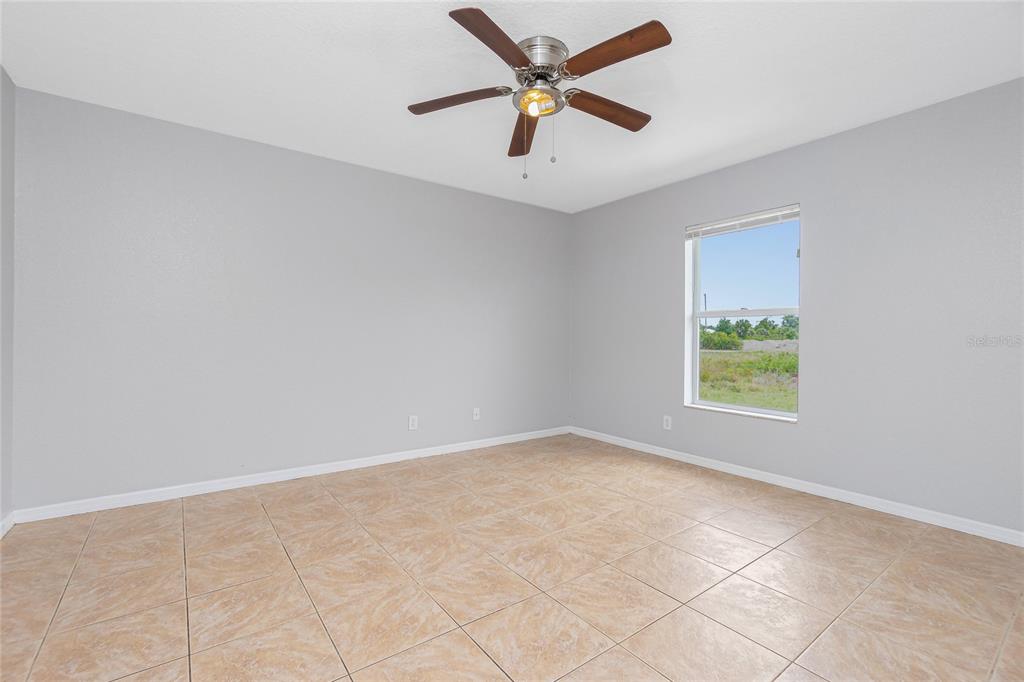 11708 Willmington Boulevard Port Charlotte, FL 33981 - Photo 25 of 41 an empty room with a window and a fan