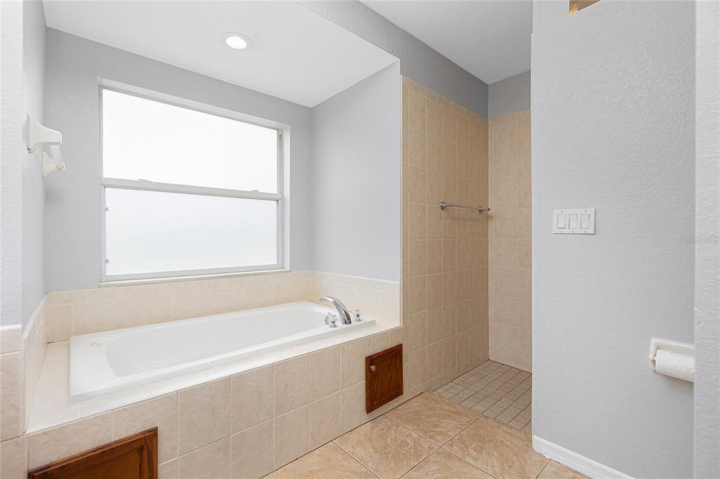 11708 Willmington Boulevard Port Charlotte, FL 33981 - Photo 28 of 41 a spacious bathroom with a bathtub and a shower