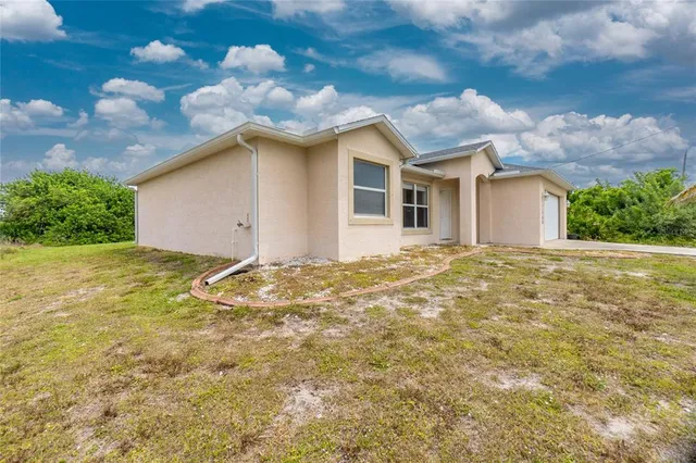 a view of a yard in front of a house with a large tree