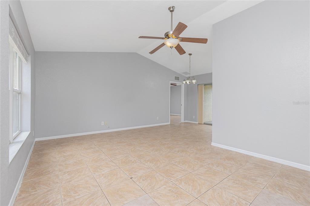 11708 Willmington Boulevard Port Charlotte, FL 33981 - Photo 6 of 41 an empty room with a ceiling fan and carpet