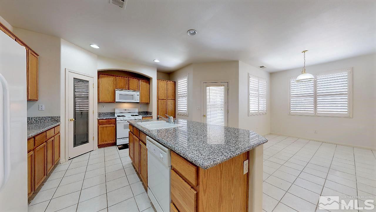 1437 Wild Wolf Way Reno, NV 89521 - Photo 5 of 20 a kitchen with stainless steel appliances granite countertop a sink and a stove
