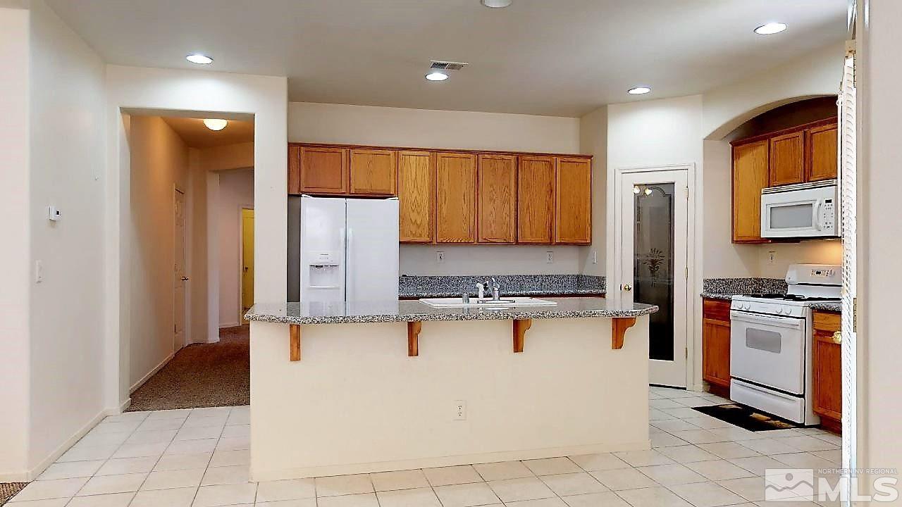 1437 Wild Wolf Way Reno, NV 89521 - Photo 6 of 20 a kitchen with stainless steel appliances granite countertop a refrigerator and a stove