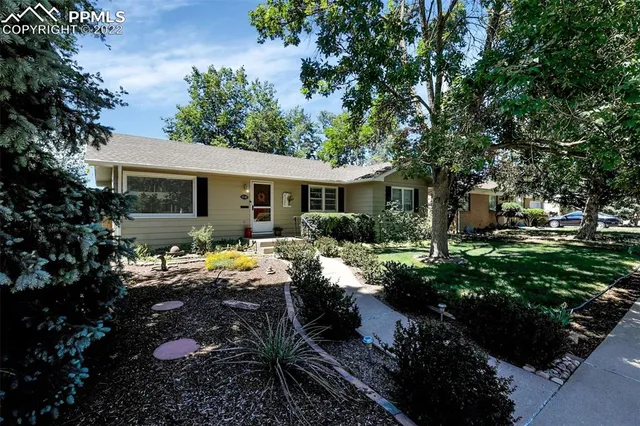 a view of house with backyard outdoor seating and green space