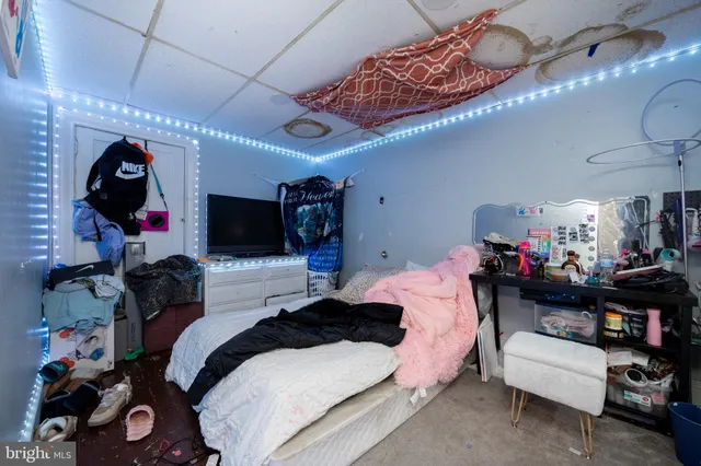 a bedroom with a bed a couch and chandelier