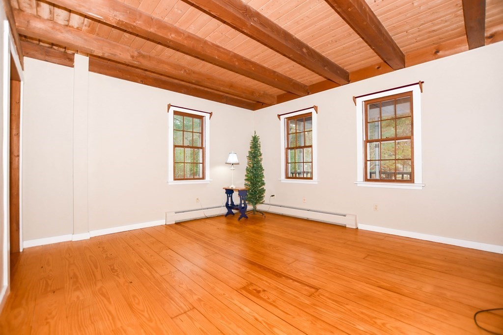 58 Alley Road Rochester, MA 02770 - Photo 18 of 29 a view of an empty room with a window and wooden floor
