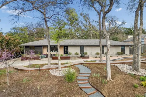 a view of a house with backyard and sitting area