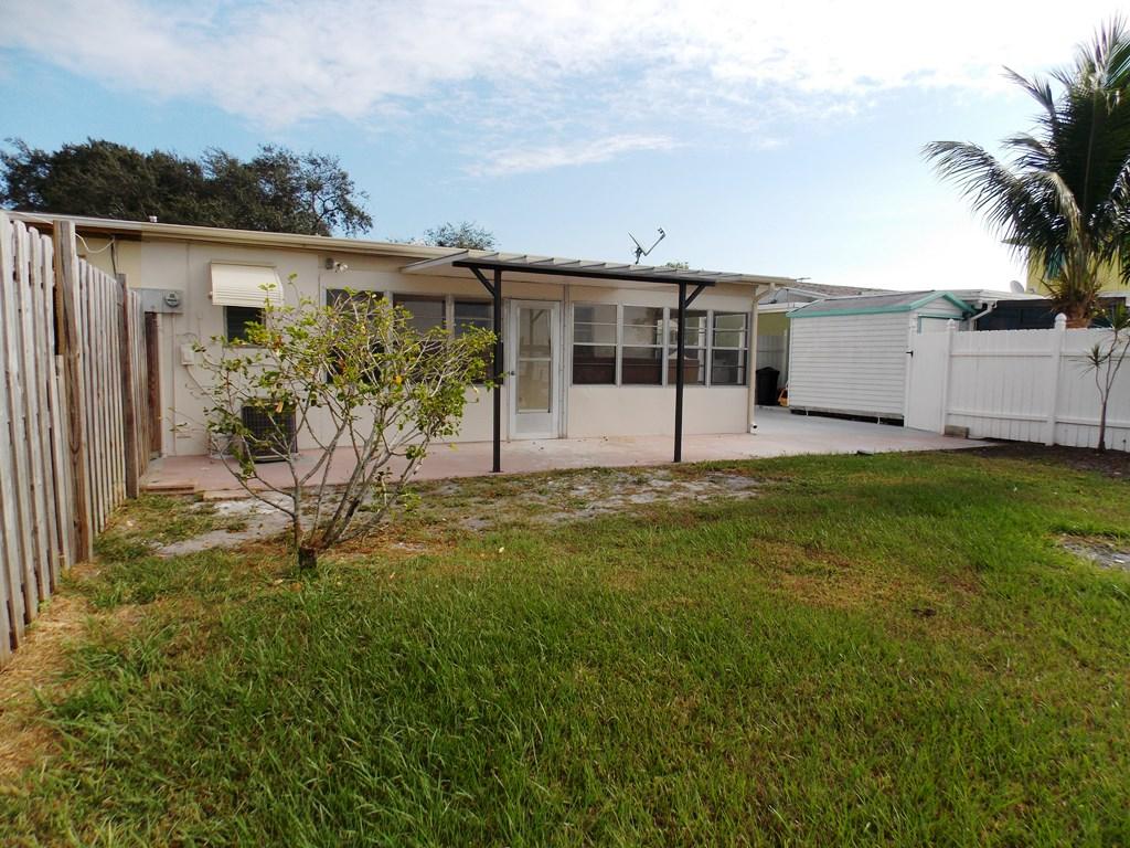 100 Southwest Hideaway Place Stuart, FL 34994 - Photo 20 of 23 a view of a backyard with potted plants and palm trees