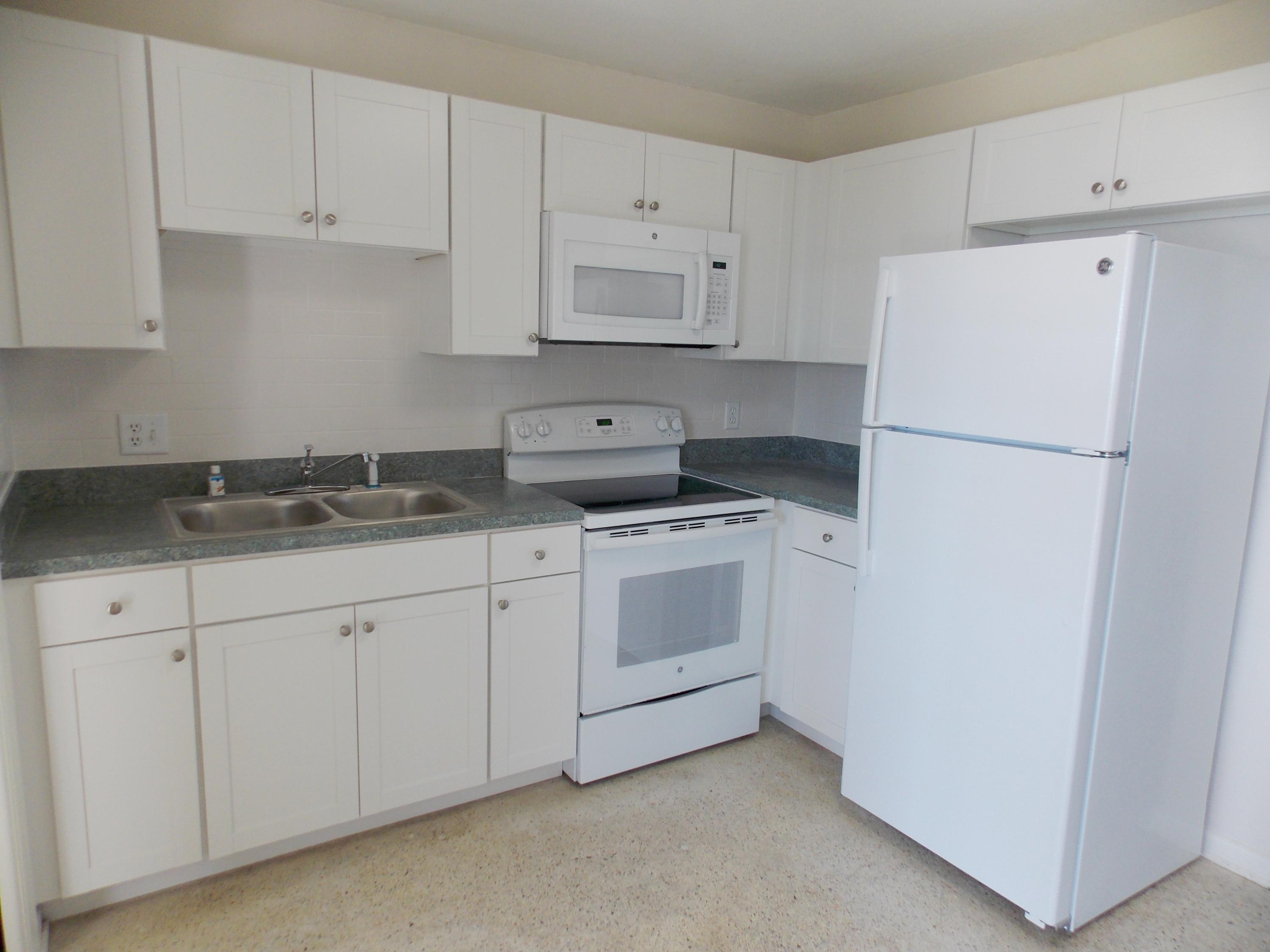 100 Southwest Hideaway Place Stuart, FL 34994 - Photo 8 of 23 a kitchen with white cabinets and white appliances