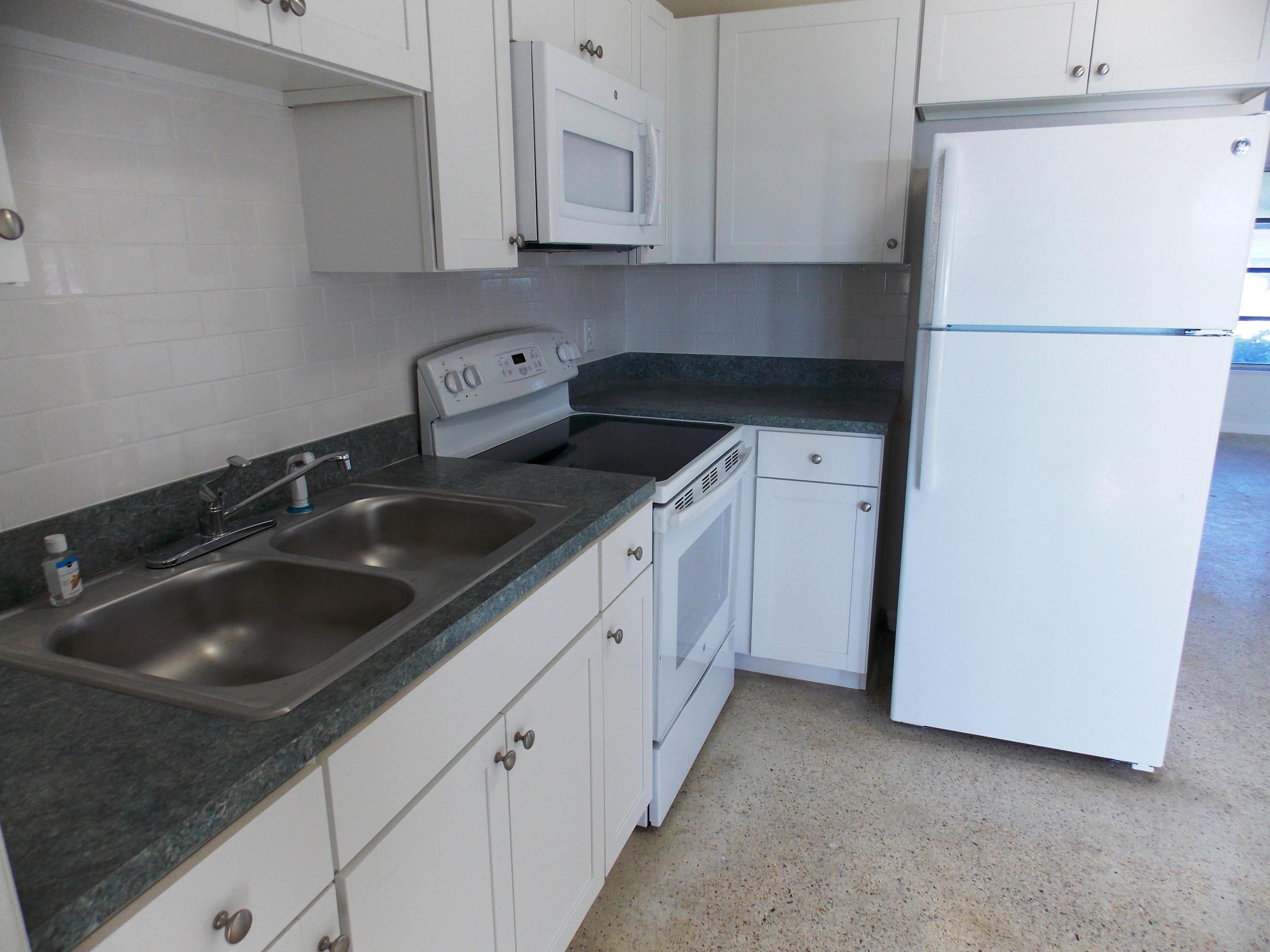 100 Southwest Hideaway Place Stuart, FL 34994 - Photo 9 of 23 a kitchen with white cabinets and white appliances