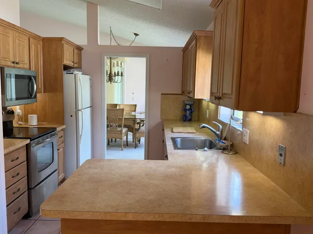 a kitchen with stainless steel appliances a sink window and a refrigerator