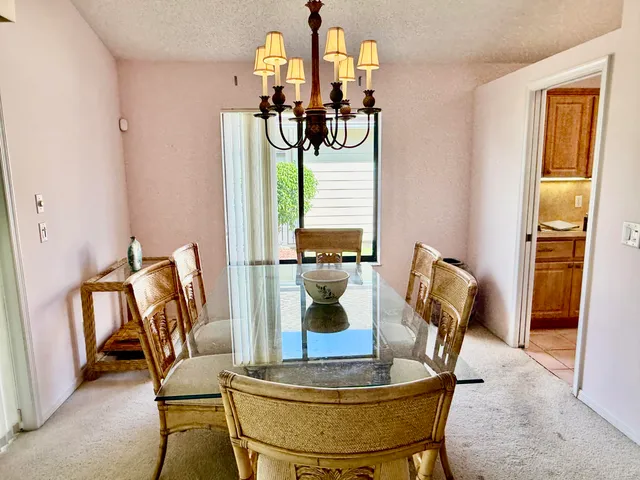 a view of a dining room with furniture a chandelier and wooden floor