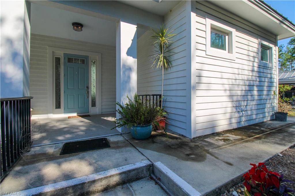 6184 Whitaker Road Naples, FL 34112 - Photo 11 of 50 a view of a house with backyard and sitting area