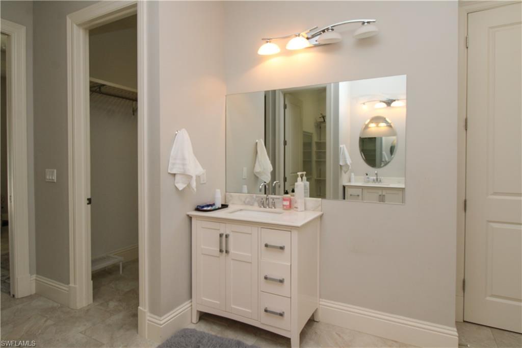 6184 Whitaker Road Naples, FL 34112 - Photo 17 of 50 a bathroom with a sink vanity and mirror