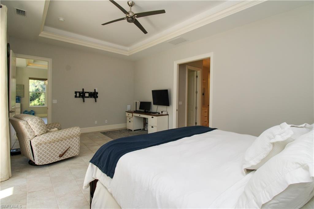 6184 Whitaker Road Naples, FL 34112 - Photo 23 of 50 a bedroom with a bed window and a flat screen tv
