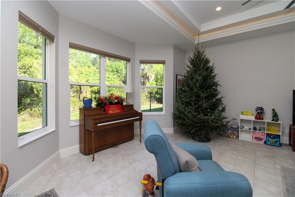 6184 Whitaker Road Naples, FL 34112 - Photo 27 of 50 a living room with furniture and a christmas tree