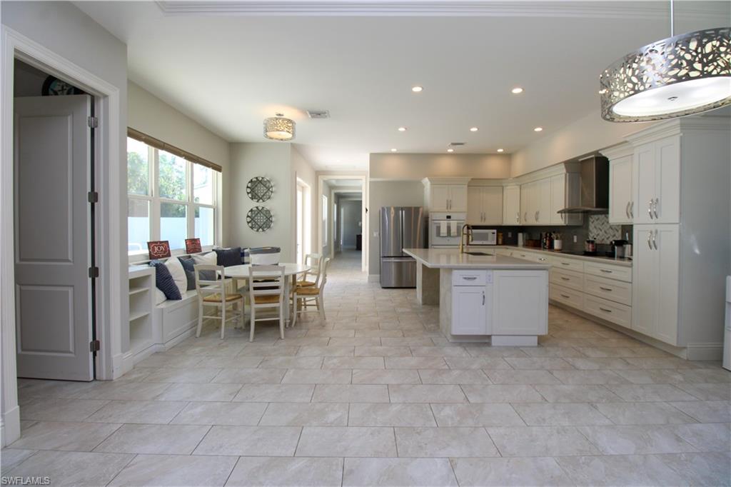 6184 Whitaker Road Naples, FL 34112 - Photo 31 of 50 a kitchen with stainless steel appliances kitchen island granite countertop a sink and cabinets
