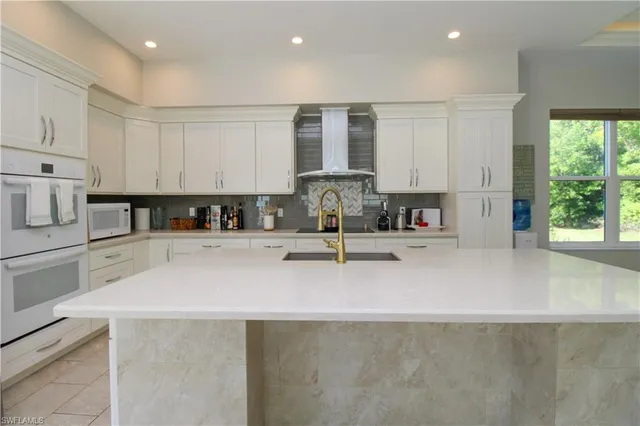 a kitchen with stainless steel appliances granite countertop a sink a stove and a refrigerator with wooden floor