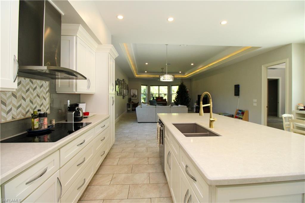 6184 Whitaker Road Naples, FL 34112 - Photo 35 of 50 a kitchen with stainless steel appliances kitchen island a sink stove and cabinets