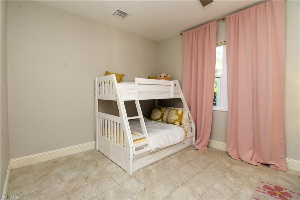 6184 Whitaker Road Naples, FL 34112 - Photo 38 of 50 a white bed sitting in a room next to a window