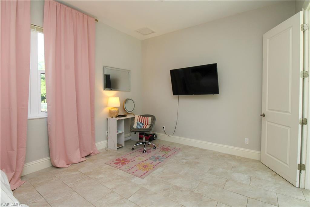 6184 Whitaker Road Naples, FL 34112 - Photo 40 of 50 a living room with furniture and a flat screen tv