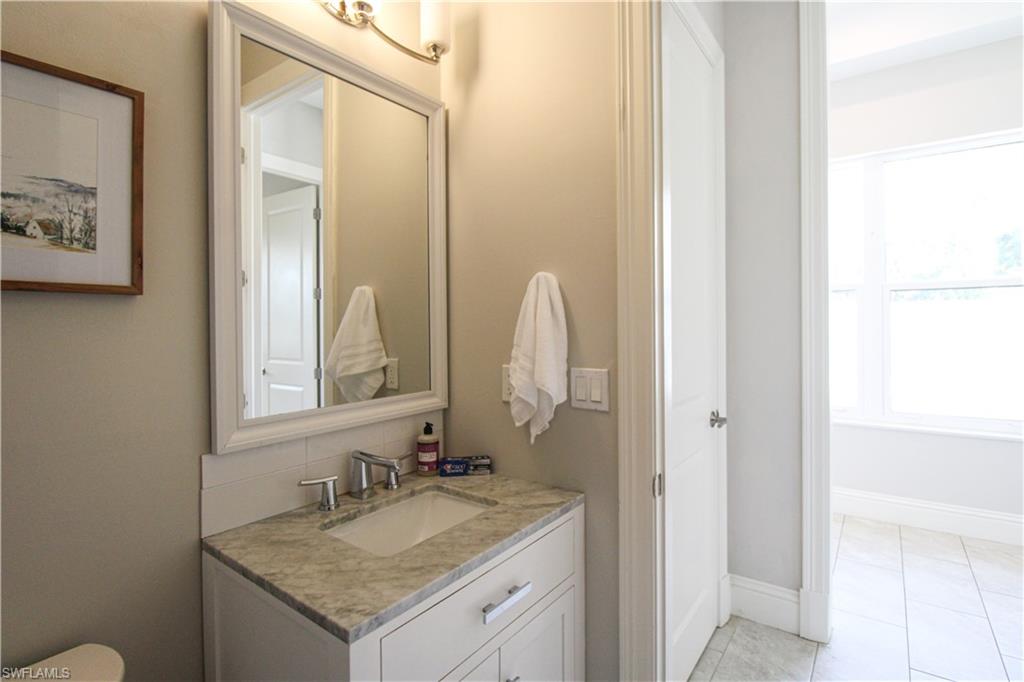 6184 Whitaker Road Naples, FL 34112 - Photo 42 of 50 a bathroom with a granite countertop sink and a mirror