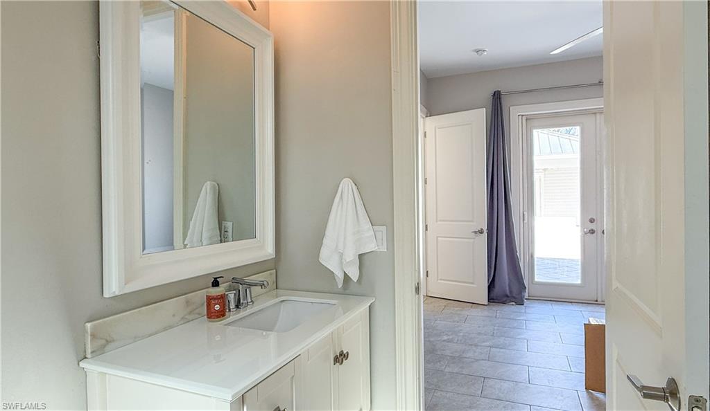 6184 Whitaker Road Naples, FL 34112 - Photo 43 of 50 a bathroom with a sink and a mirror