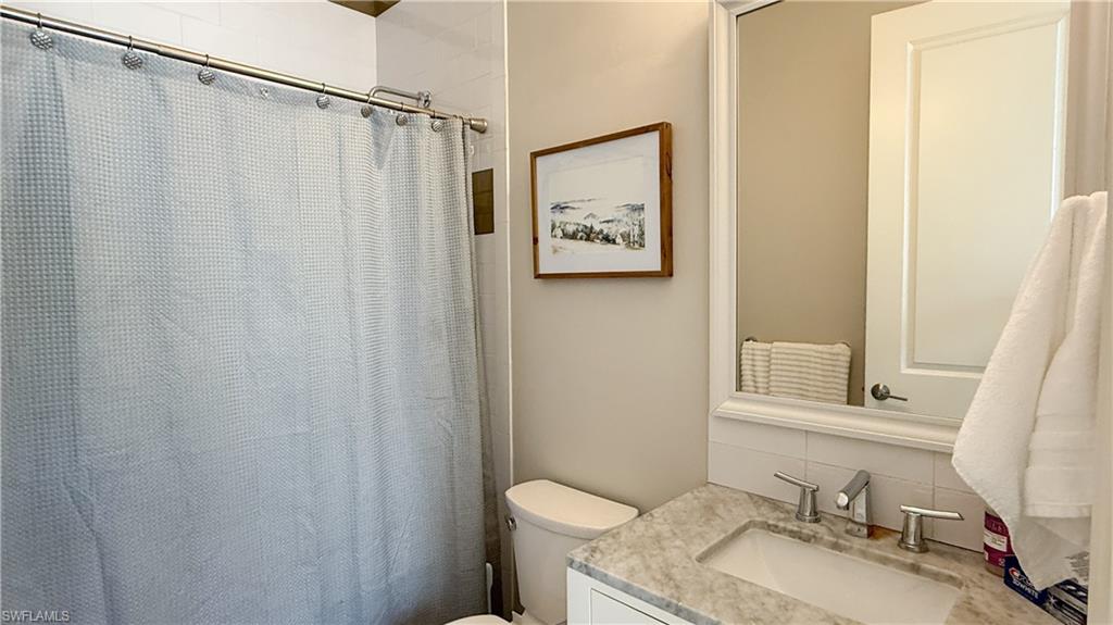 6184 Whitaker Road Naples, FL 34112 - Photo 44 of 50 a bathroom with a granite countertop sink and a mirror