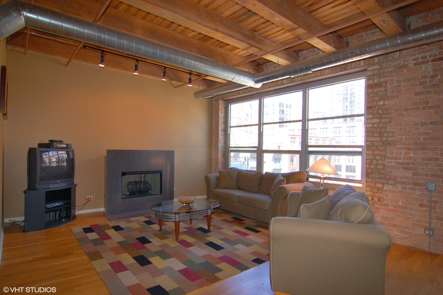 333 South Desplaines Street, Unit 605 Chicago, IL 60661 - Photo 2 of 8 a living room with furniture wooden floor and a fireplace