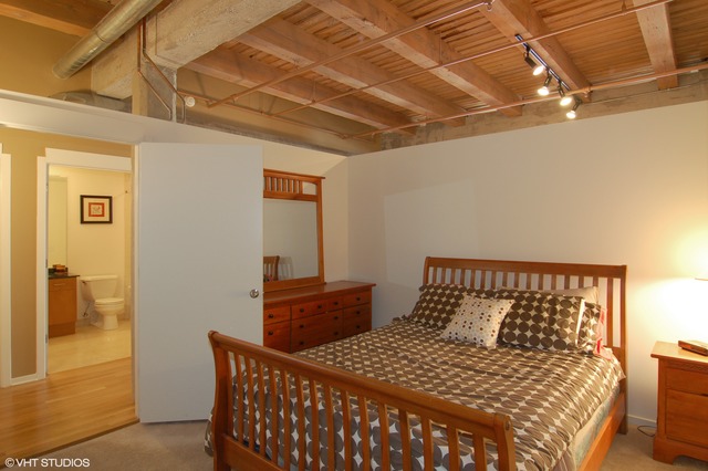 333 South Desplaines Street, Unit 605 Chicago, IL 60661 - Photo 6 of 8 a bedroom with a bed and wooden floor