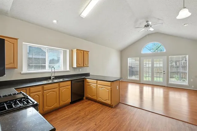 a large kitchen with stainless steel appliances a large window a oven and a counter space